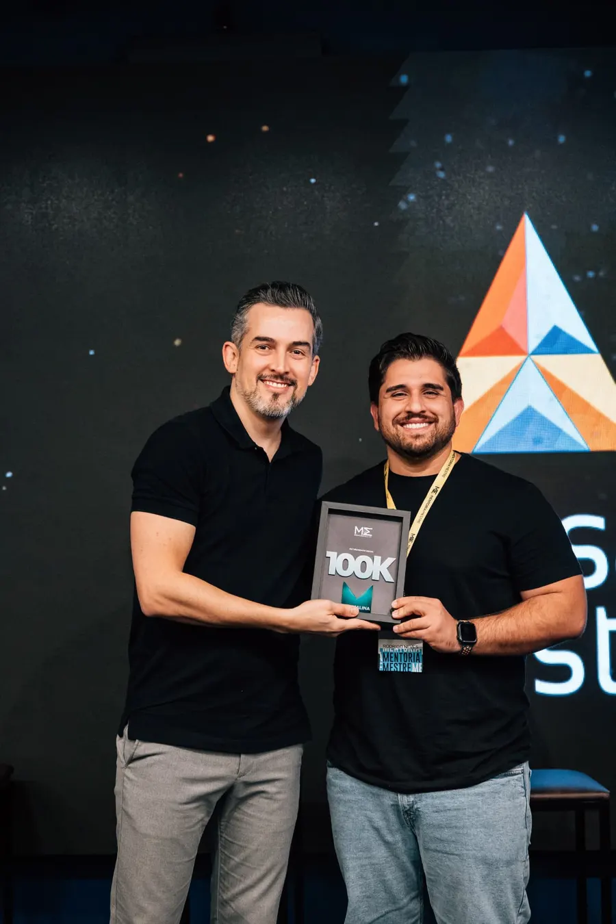 Rodrigo Neves recebendo a placa de reconhecimento de faturamento em um palco