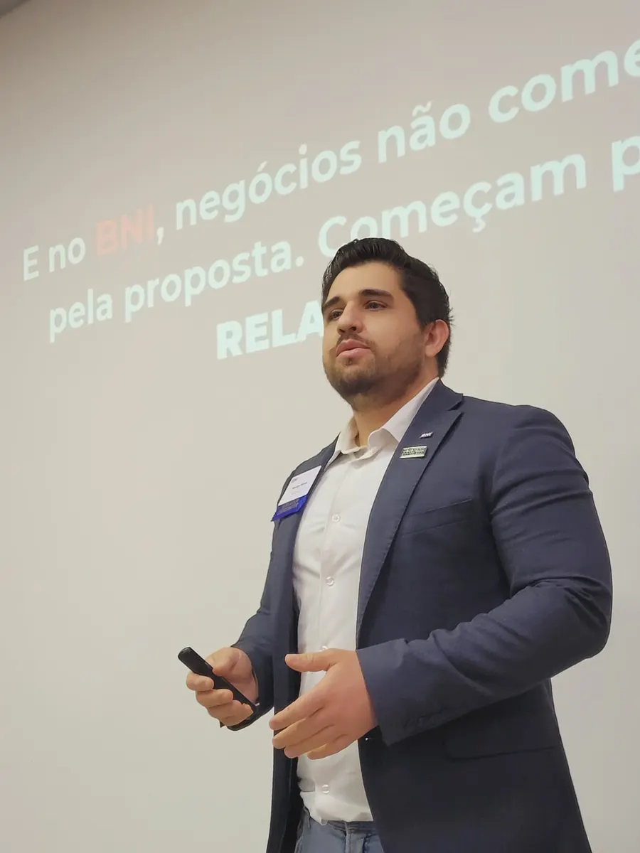 Rodrigo Neves de blazer apresentando uma palestra em frente ao telão